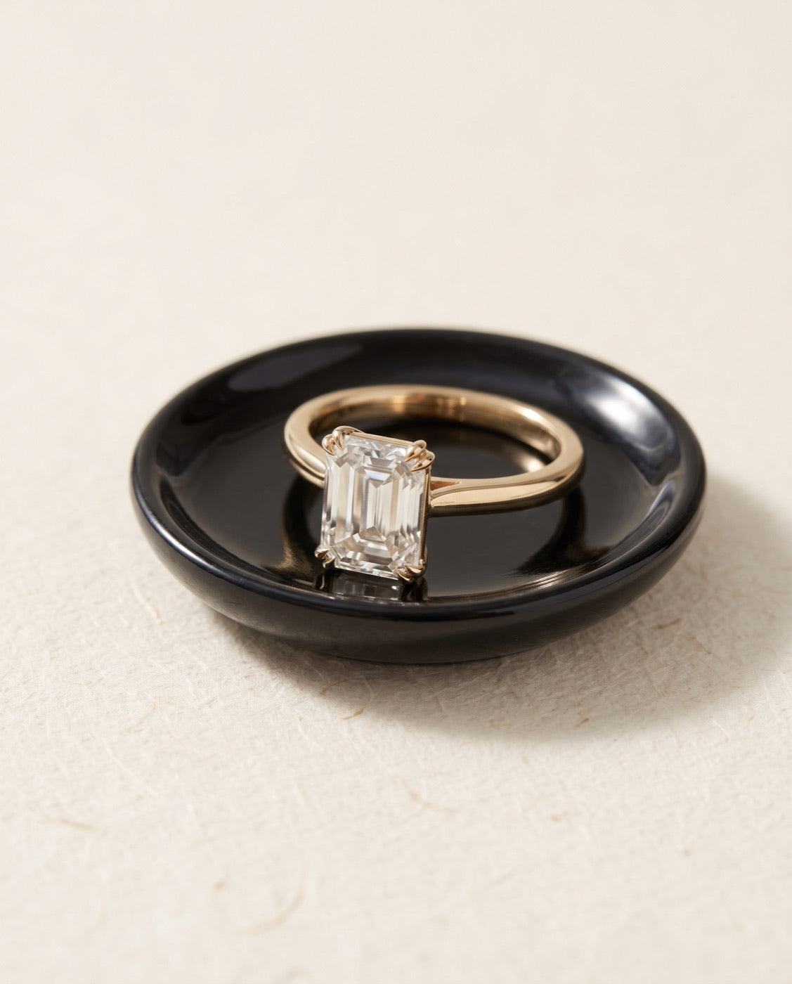 Ring in 18K geelgoud met een emerald cut lab-diamant op een zwart schaaltje